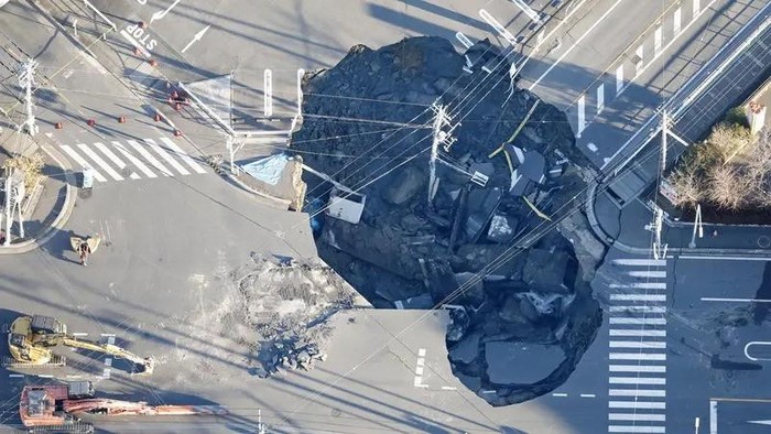 An aerial view shows a large sinkhole that formed when a sinkhole that swallowed a truck and a man believed to be its driver at an intersection in Yashio, formed on January 28, 2025, and another that formed during rescue operations, merged, near Tokyo, Japan January 30, 2025, in this photo taken by Kyodo. (Reuters)