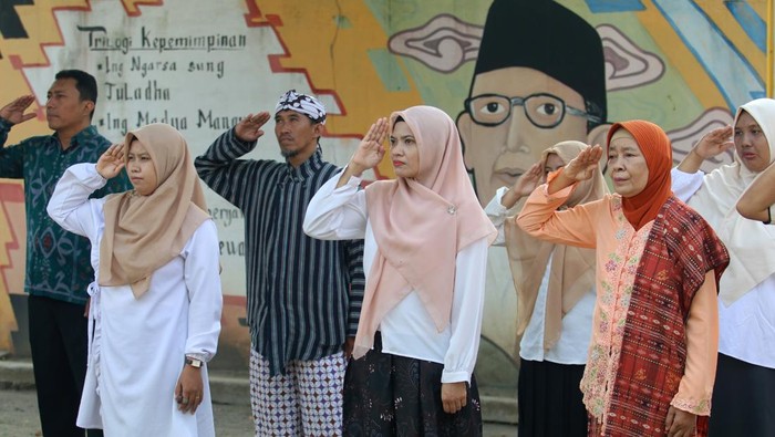 Semarak Peringatan Hardiknas 2025 di Berbagai Daerah Sejumlah guru SMK yayasan Perguruan Tamansiwa mengikuti upacara bendera dengan latar belakang gambar pahlawan nasional Ki Hadjar Dewantara saat memperingati Hari Pendidikan Nasional di Kota Kediri, Jawa Timur, Jumat (2/5/2025). Kegiatan tersebut diisi dengan upacara bendera dengan mengenakan baju daerah dan menggunakan Bahasa Jawa. ANTARA FOTO/Prasetia Fauzani/nym.