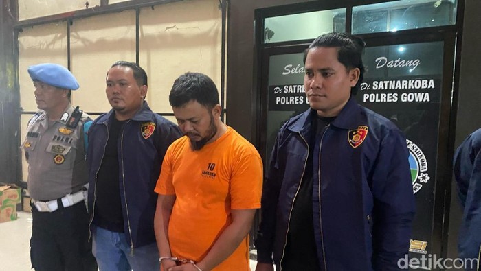 Tampang pegawai honorer di Gowa berbaju tahanan usai menipu mahasiswa modus proyek fiktif.