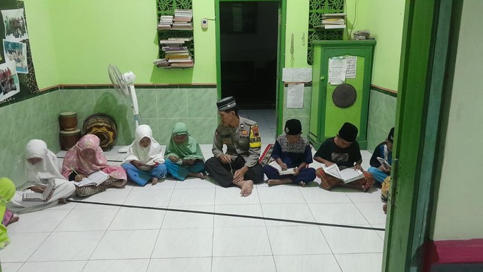 Bhabinkamtibmas Polsek Pancur, Aipda Jawahir, mengajar anak-anak mengaji hingga menulis di Musala Tsabit Bin Qoisy, Desa Warugunung, Kecamatan Pancur, Rembang.