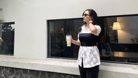 Momen ketika ia berpose di depan kafe juga diunggah di Instagramnya. Valerie pun membeli segelas minuman es kopi susu dari kafe tersebut. Foto: Instagram @valtifanka