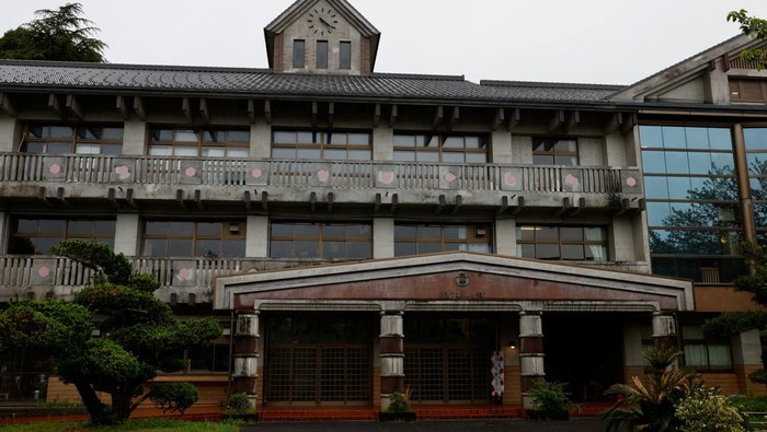 Tourists from abroad wearing school uniforms listen to a woman playing a teacher at a class room while taking part in a Japanese high school experience in Kimitsu, Chiba prefecture, Japan April 23, 2025.  REUTERS/Manami Yamada