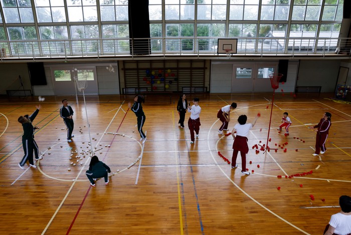 Tourists from abroad wearing school uniforms listen to a woman playing a teacher at a class room while taking part in a Japanese high school experience in Kimitsu, Chiba prefecture, Japan April 23, 2025.  REUTERS/Manami Yamada