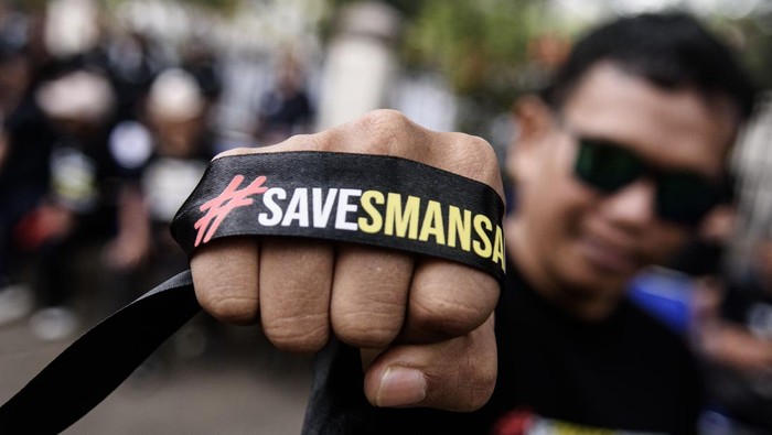 Warga melintas di dekat karangan bunga dukungan untuk SMA Negeri 1 (SMANSA) Bandung saat aksi simpatik di depan gedung sekolah SMA Negeri 1 Bandung, Jawa Barat, Minggu (4/5/2025). Aksi tersebut sebagai bentuk solidaritas dan dukungan kepada SMA Negeri 1 Bandung terkait sengketa lahan usai putusan Pengadilan Tata Usaha Negara (PTUN) Bandung yang mengabulkan gugatan atas kepemilikan yang diajukan Perkumpulan Lyceum Kristen. ANTARA FOTO/Novrian Arbi/tom.