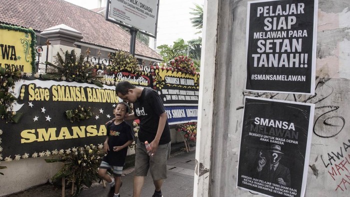 Aksi dukungan untuk SMA Negeri 1 Bandung Warga melintas di dekat karangan bunga dukungan untuk SMA Negeri 1 (SMANSA) Bandung saat aksi simpatik di depan gedung sekolah SMA Negeri 1 Bandung, Jawa Barat, Minggu (4/5/2025). Aksi tersebut sebagai bentuk solidaritas dan dukungan kepada SMA Negeri 1 Bandung terkait sengketa lahan usai putusan Pengadilan Tata Usaha Negara (PTUN) Bandung yang mengabulkan gugatan atas kepemilikan yang diajukan Perkumpulan Lyceum Kristen. ANTARA FOTO/Novrian Arbi/tom.