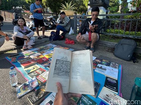 Komunitas baca ngelapak buku, masyarakat bisa baca buku gratis di Taman Kota Singaraja, Buleleng, Bali, Minggu (4/5/2025). (Made Wijaya Kusuma)