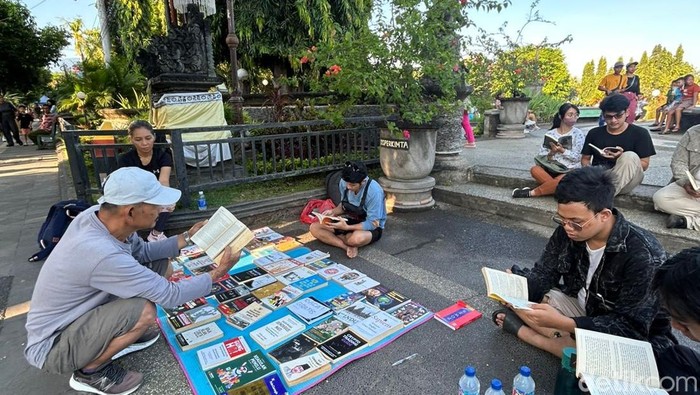 Komunitas baca ngelapak buku, masyarakat bisa baca buku gratis di Taman Kota Singaraja, Buleleng, Bali, Minggu (4/5/2025). (Made Wijaya Kusuma)