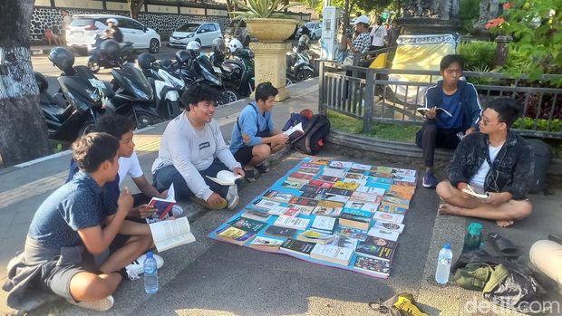 Komunitas baca ngelapak buku, masyarakat bisa baca buku gratis di Taman Kota Singaraja, Buleleng, Bali, Minggu (4/5/2025). (Made Wijaya Kusuma)