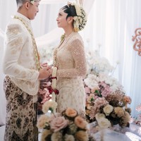 Kedua pengantin tampil kompak dalam balutan busana adat Jawa Solo berwarna putih gading. Diketahui busana pengantin yang dikenakan berasal dari KaaraBride by Mutiara Meddyan. Foto: Instagram/@valtifanka