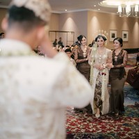 Momen pertama Mochammad Andhika bertemu dengan Valerie di hari pernikahannya. Sambil digandeng oleh kedua bridesmaid yang salah satunya ialah Febby Rastanty, Valerie tampil menawan dengan kebaya lengkap dengan sanggul, paes, dan ronce melati di kepalanya. Foto: Instagram/@valtifanka