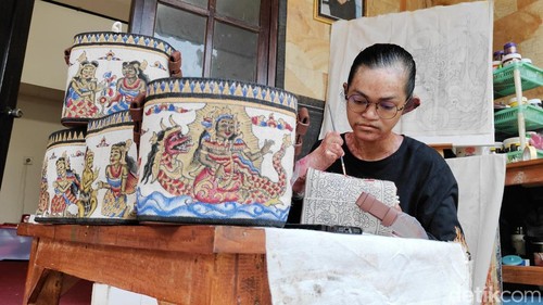 Wayan Abdi Arya Nugraha alias Dikyan sangat terampil melukis tas kulit di rumahnya di Desa Bongkasa, Badung. (Agus Eka)