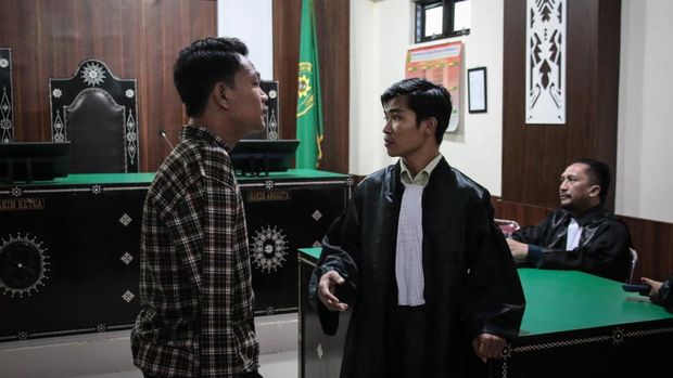 Petugas kepolisian mengawal terdakwa selaku penyandang tunadaksa I Wayan Agus Suartama alias Agus Buntung (kiri) berjalan menuju mobil tahanan usai menjalani sidang tuntutan kasus pelecehan seksual di Pengadilan Negeri Mataram, NTB, Senin (5/5/2025). Jaksa penuntut umum menuntut agar hakim menjatuhkan pidana hukuman 12 tahun penjara dan denda Rp100 juta subsider 3 bulan kurungan pengganti dengan mempertimbangkan jumlah korban yang lebih dari satu orang dan terdakwa Agus Buntung tidak mengakui dan menyesali perbuatannya. ANTARA FOTO/Dhimas Budi Pratama/sgd/foc.
