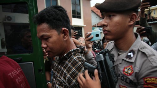 Petugas kepolisian mengawal terdakwa selaku penyandang tunadaksa I Wayan Agus Suartama alias Agus Buntung (kiri) berjalan menuju mobil tahanan usai menjalani sidang tuntutan kasus pelecehan seksual di Pengadilan Negeri Mataram, NTB, Senin (5/5/2025). Jaksa penuntut umum menuntut agar hakim menjatuhkan pidana hukuman 12 tahun penjara dan denda Rp100 juta subsider 3 bulan kurungan pengganti dengan mempertimbangkan jumlah korban yang lebih dari satu orang dan terdakwa Agus Buntung tidak mengakui dan menyesali perbuatannya. ANTARA FOTO/Dhimas Budi Pratama/sgd/foc.