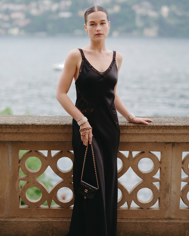 Aktris dan penyanyi Amerika Sarah Catherine Hook berbusana serba hitam dengan silk dress berhias lace dan clutch. Sarah menampilkan tren kecantikan ‘clean girl aesthetic’ dengan riasan wajah nude natural dan rambut yang disanggul sleek ke belakang. Foto: Instagram/@chanel