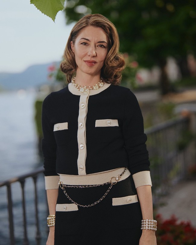 Sutradara Sofia Coppola menonjolkna gaya Parisian chic dengan setelan rajut berupa cardigan dan rok midi yang dipermanis aksen list warna beige. Foto: Instagram/@chanel