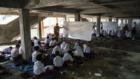 Sejumlah siswa kelas 3 dan 6 terpaksa mengikuti kegiatan belajar mengajar di kolong bangunan SD Negeri Bedono 1, Sayung, Kabupaten Demak, Jawa Tengah, Senin (5/5/2025).  