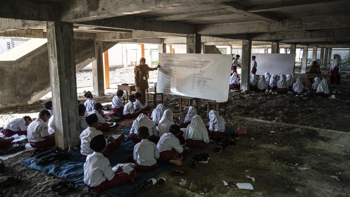 Gedung Baru Terkunci, Siswa SDN Bedono 1 Belajar di Kolong Sejumlah siswa kelas 3 mengikuti kegiatan belajar mengajar di kolong bangunan SD Negeri Bedono 1, Sayung, Kabupaten Demak, Jawa Tengah, Senin (5/5/2025). Menurut Komite Sekolah setempat, gedung baru SDN Bedono 1 yang dibangun sebagai relokasi proyek Tol Laut Semarang-Demak seharusnya sudah dapat digunakan, namun seluruh ruangannya masih terkunci oleh kontraktor, sehingga kegiatan belajar mengajar terpaksa dilakukan di kolong bangunan. ANTARA FOTO/Aprillio Akbar/bar