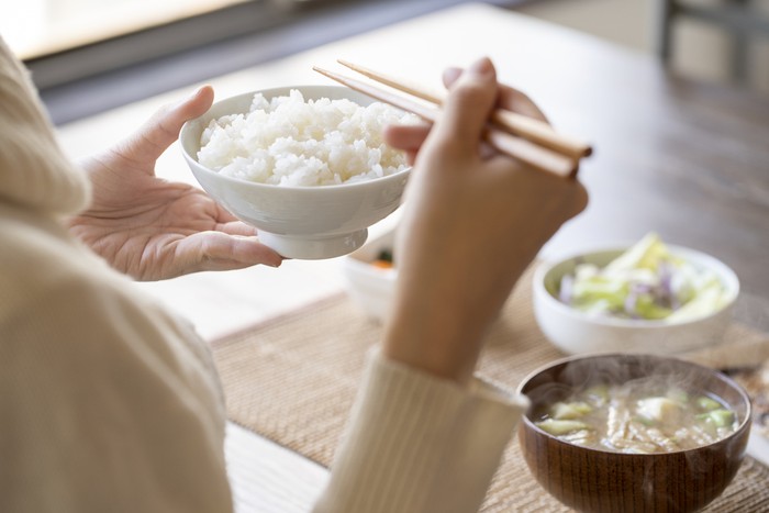 Hand of young woman eating breakfast