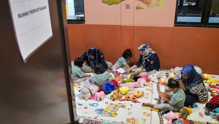 Intip Tempat Penitipan Anak Gratis bagi MBR di Jakarta Sejumlah petugas membacakan buku kepada anak-anak yang diasuh di Taman Anak Sejahtera Arutala (TAS), Kebon Bawang, Jakarta Utara, Senin (5/5/2025). Dinas Sosial DKI Jakarta menyediakan tempat penitipan atau pengasuhan anak gratis dengan fasilitas kelas belajar, kelas bermain, makan hingga ruang tidur yang dapat menampung 25 anak usia 2-6 tahun bagi orang tua berpenghasilan rendah yang harus bekerja. ANTARA FOTO/Sulthony Hasanuddin/bar