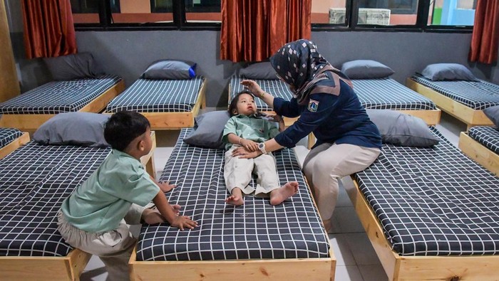 Intip Tempat Penitipan Anak Gratis bagi MBR di Jakarta Sejumlah petugas membacakan buku kepada anak-anak yang diasuh di Taman Anak Sejahtera Arutala (TAS), Kebon Bawang, Jakarta Utara, Senin (5/5/2025). Dinas Sosial DKI Jakarta menyediakan tempat penitipan atau pengasuhan anak gratis dengan fasilitas kelas belajar, kelas bermain, makan hingga ruang tidur yang dapat menampung 25 anak usia 2-6 tahun bagi orang tua berpenghasilan rendah yang harus bekerja. ANTARA FOTO/Sulthony Hasanuddin/bar