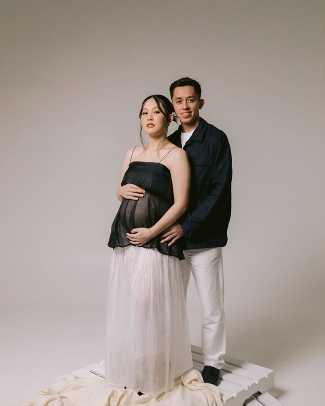 Dengan latar putih polos dan pencahayaan yang soft, sesi foto ini menonjolkan ekspresi wajah serta koneksi emosional antara pasangan. Sederhana namun tetap menyampaikan kisah yang bermakna. Foto: Instagram @ribkasugiarto/ @rianardianto