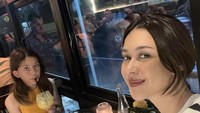 Bersama anak perempuannya, putri Lydia Kandou menikmati makan malam di restoran. Beberapa jenis makanan, termasuk pizza tersaji di meja. Foto: Instagram @nanamirdad_