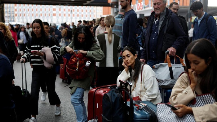 Passengers wait to be given access to their trains after cable stolen from a high-speed train line between Madrid and Andalusia caused delays at Atocha station in Madrid, Spain, May 5, 2025. REUTERS/Susana Vera