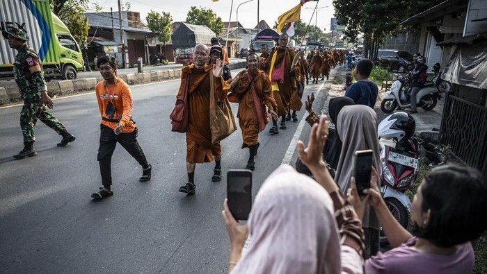 Sejumlah biksu yang mengikuti ritual Thudong menyapa warga saat berjalan kaki di Jalan Raya Soekarno Hatta, Kabupaten Kendal, Jawa Tengah, Senin (5/5/2025). Sebanyak 36 biksu yang melakukan perjalanan ritual Thudong dari Thailand menuju Candi Borobudur untuk menyambut Hari Raya Waisak pada 12 Mei 2025, tiba di Kabupaten Kendal dan akan bermalam di Gereja St Antonius Padua. ANTARA FOTO/Aprillio Akbar/foc.