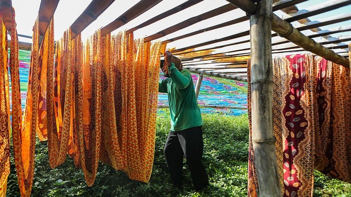 2212591560 A worker dries traditionally patterned beach fabrics under the scorching sun at a home-based garment industry center in Sukoharjo, Central Java, Indonesia, on May 1, 2025. According to Statistics Indonesia (BPS), as of August 2024, 83.83 million people, equivalent to 57.95% of the total employed population, work in the informal sector. (Photo by Agoes Rudianto/NurPhoto via Getty Images)