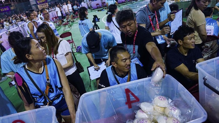 People take part in a bun scrambling competition during Bun Festival at Cheung Chau island in Hong Kong, China May 6, 2025. REUTERS/Lam Yik