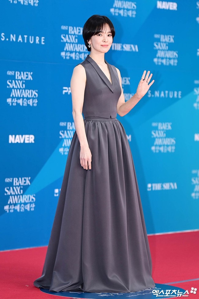 Song Hye Kyo menyihir penggemar dengan pesonanya saat tiba di red carpet. Alih-alih memakai gaun, bintang film Dark Nuns itu berbalut charcoal gray suit dan long skirt set. Penampilannya dilengkapi koleksi perhiasan anting dan cincin dari Chaumet. Foto: Instagram