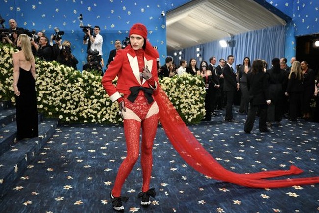 Pada Met Gala 2025 yang mengusung tema “Superfine: Tailoring Black Style,” Amelia Gray Hamlin tampil mencolok dengan busana merah menyala rancangan Valentino. Amelia mengenakan bodysuit renda berwarna dan jaket tuxedo cropped. Foto: AFP/ANGELA WEISS