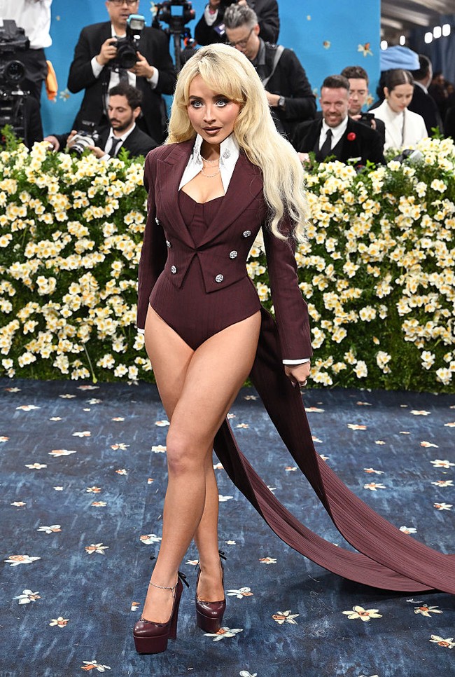 Gaya pantless yang mulai populer pada tahun 1960-70an menghiasi Met Gala 2025. Gaya pantless biasanya muncul dalam bentuk leotard, bodysuit, atau mini dress yang sangat pendek. Seperti gaya Sabrina Carpenter ini yang memakai unitard warna burgundy dan crop blazer yang dihiasi ekor. Foto: Variety via Getty Images/Gilbert Flores