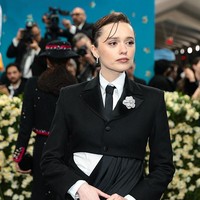 Bintang serial White Lotus, Aimee Lou Wood, debut di Met Gala 2025 dengan gaya pantless. Aimee memakai jaket cropped hitam yang dipadukan dengan kemeja putih dan dasi hitam. Bagian bawah busananya menampilkan desain unik, sebelah sisi berupa rok panjang terbuka dari sutra, sementara sisi lainnya berupa celana super pendek. Foto: Getty Images for The Met Museum//Dimitrios Kambouris