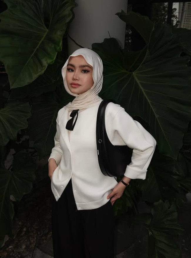 Sashfir memadukan hijab pashmina meleyot warna broken white dengan atasan putih dan bawahan warna hitam. Tampil dengan riasan mata yang tajam, penampilan Sashfir terlihat elegan.  Foto: Dok. Instagram @sashfir.