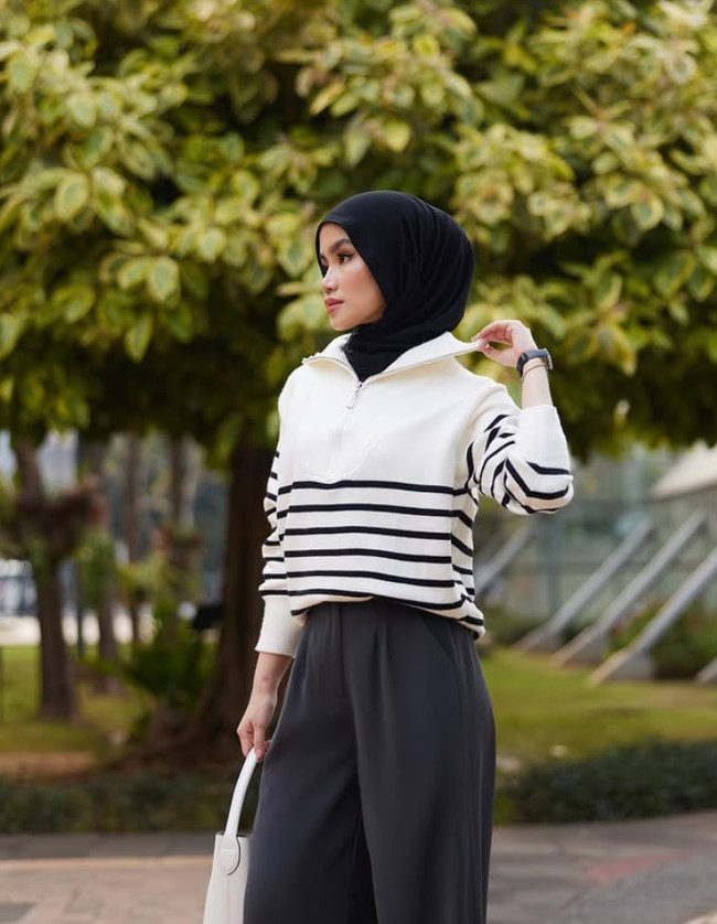 Warna basic yang timeless bisa juga menjadi pilihan kamu dalam berbusana sehari-hari. Seperti gaya Sashfit ini yang memadukan atasan knit putih dengan garis-garis hitam dengan palazzo pants hitam. Ia menata hijab pashmina meleyot dengan cara memasukkan ke dalam kerah baju membuat kesan clean look. Foto: Dok. Instagram @sashfir.
