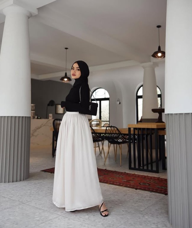 Influencer hijab kelahiran 4 Agustus 1997 ini memadukan atasan dan hijab pashmina hitam dengan rok putih. Gaya ini bisa kamu sontek saat ingin menghadiri acara formal.  Foto: Dok. Instagram @sashfir.
