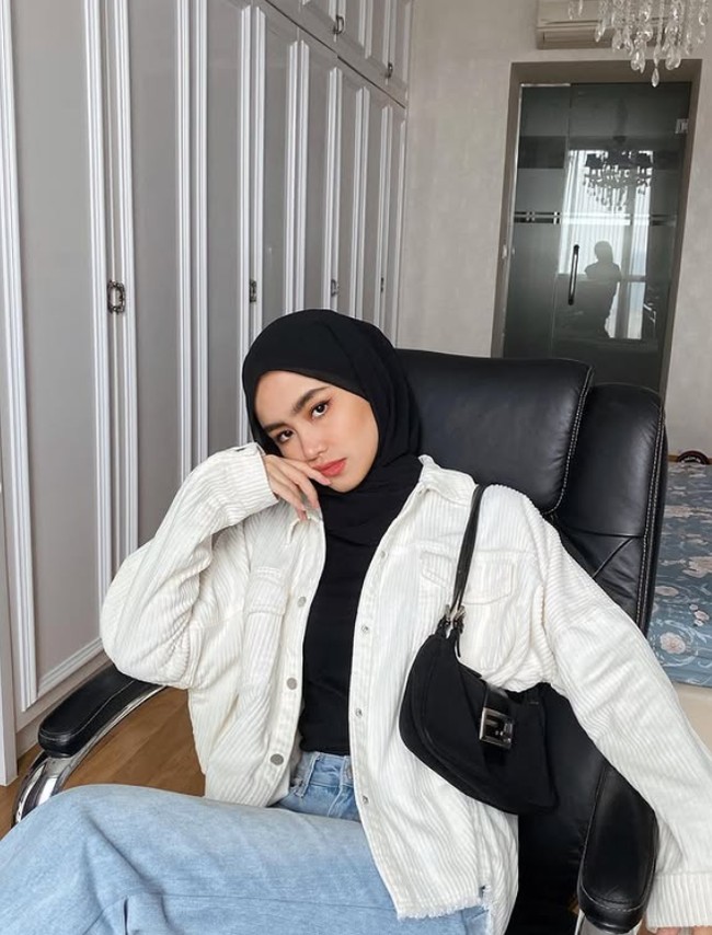 Sashfir mengenakan jacket corduroy broken white dengan dalaman dan hijab meleyot warna hitam. Agar tampil casual, ia memadukan outfit dengan jeans. Foto: Dok. Instagram @sashfir.