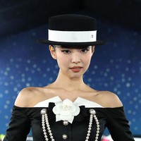 Jennie memilih risan wajah minimalis bernuansa nude cokelat. Topi model boater hat hadir sebagai pelengkap gaya. Foto: Kevin Mazur/Getty Images for The/Kevin Mazur/MG25