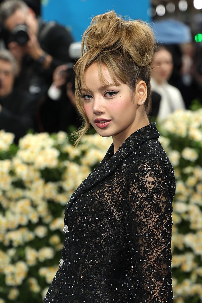 Menambah kesan glamor, Lisa menata rambutnya dengan sanggul tinggi dan dibuat lebih bervolume di bagian atas. Winged eyeliner pada mata yang memberi kesan seksi menggoda tetap ditampilkan sebagai gaya makeup ikonik bintang serial ‘White Lotus’ ini. Foto: Getty Images for The Met Museum//Dimitrios Kambouris