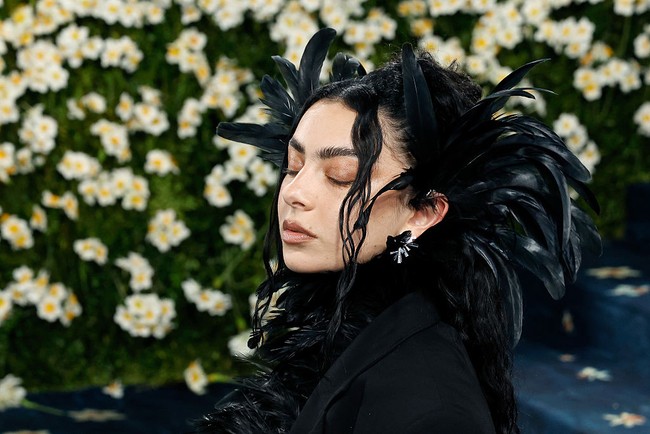Penyanyi Charli XCX datang ke Met Gala dengan tampilan gothic. Namun tema tersebut cukup di busananya saja. Charli tidak mengenakan riasan berat bertema smokey eyes, bahkan tanpa maskara. Foto: dok. Getty Images