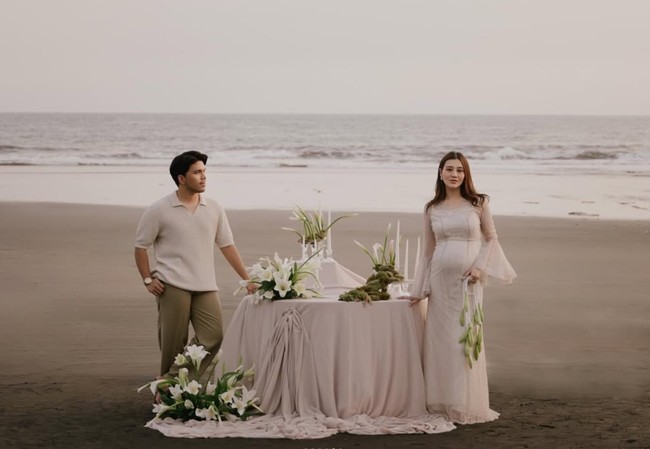 Di salah satu foto terlihat dekorasi berupa meja yang sudah ditutup kain putih dan dipercantik dengan lilin serta bunga-bunga putih. Didominasi warna putih, pemotretan maternity Aaliyah terlihat elegan. Foto: Instagram/@aaliyah.massaid