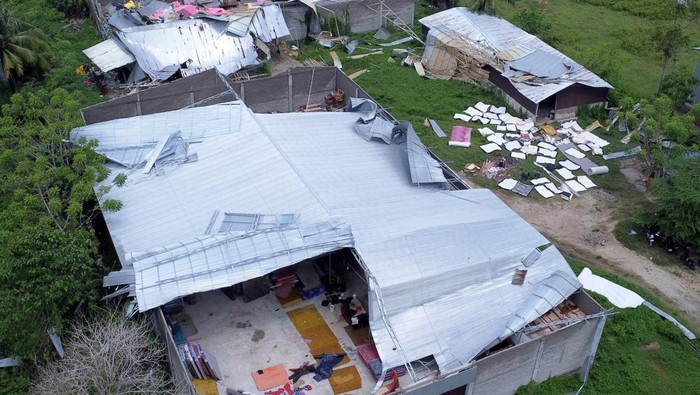 Warga menjemur bantal, kasur dan pakaian di depan rumah yang rusak pada bagian atapnya setelah diterjang angin puting beliung di Pentadio Timur, Kabupaten Gorontalo, Gorontalo, Selasa (6/5/2025). Pemerintah Daerah setempat mencatat sebanyak 104 rumah di empat desa yaitu Ulapato A, Pentadio Timur, Pentadio Barat dan Timuato rusak berat dan ringan akibat diterjang angin puting beliung pada Senin (5/5). ANTARA FOTO/Adiwinata Solihin/Spt.
