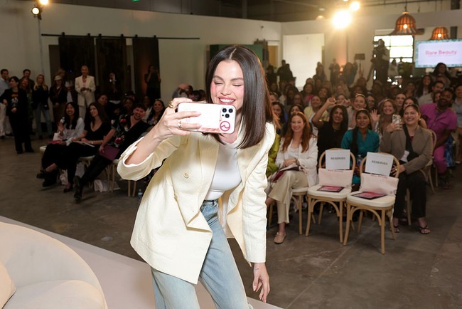 Selena memilih jeans model high-waist  dengan potongan flare. Detail layering denim di bagian dalam kaki celana menciptakan aksen visual yang unik, sekaligus membawa nuansa retro. Foto: Getty Images for Rare Beauty/Stefanie Keenan