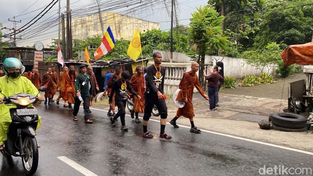 Para biksu thudong kembali melanjutkan perjalanan di tengah hujan, di Jalan Perintis Kemerdekaan, Kelurahan Pudak Payung, Kecamatan Banyumanik, Kota Semarang, Rabu (7/5/2025).