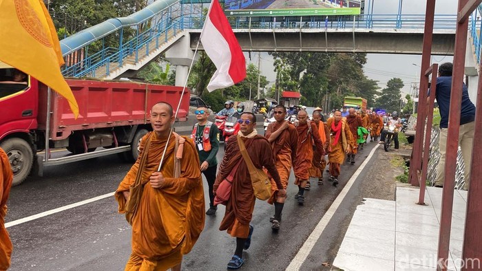 Para biksu thudong kembali melanjutkan perjalanan di tengah hujan, di Jalan Perintis Kemerdekaan, Kelurahan Pudak Payung, Kecamatan Banyumanik, Kota Semarang, Rabu (7/5/2025).