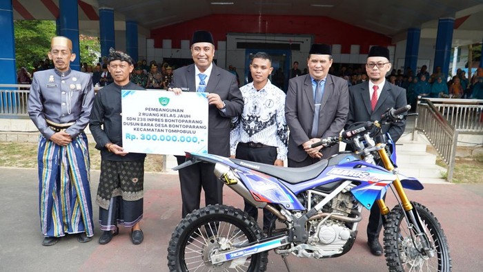 Bupati Maros Chaidir Syam menyerahkan bantuan Rp 300 juta dan sepeda motor trail untuk pembangunan Sekolah Kolong di Tompobulu. Dokumen Istimewa