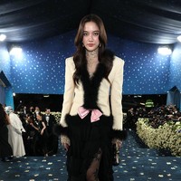 Penampilan aktris Thailand, Freen Sarocha tak kalah mencuri perhatian saat tiba di blue carpet Met Gala 2025. Brand ambassador terbaru Valentino itu mengenakan blazer berwarna nude, yang berhias bulu dan aksen pita. Di balik rok hitam yang menjuntai, dia memakai stocking bermotif floral. Foto: Getty Images