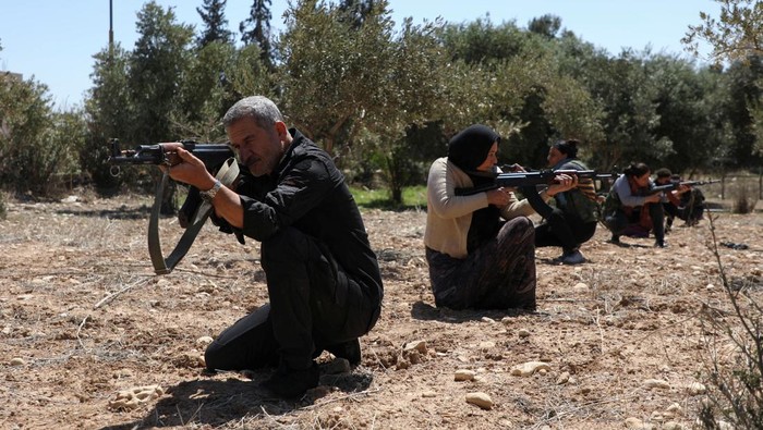 Kurdish women and men attend a training on how to use weapons in Qamishli, Syria April 18, 2025. REUTERS/Orhan Qereman
