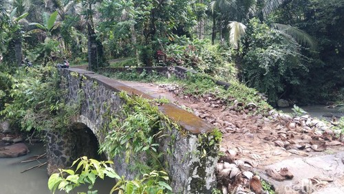 Perbekel Desa Gadungsari, I Wayan Sindreg saat menunjukkan jembatan jebol yang diurug menggunakan serabut kelapa.